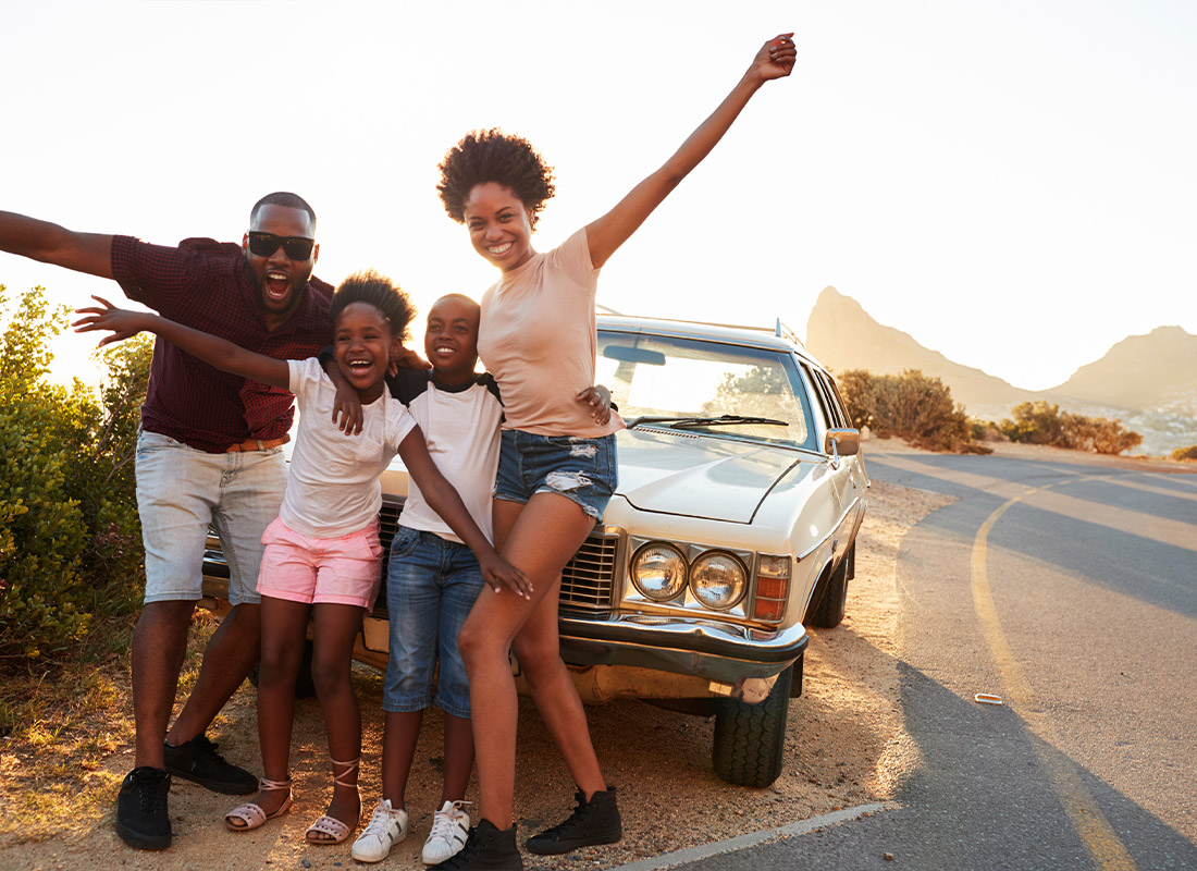 Insurance Solutions - Young Family Taking a Photo by Their Classic Car